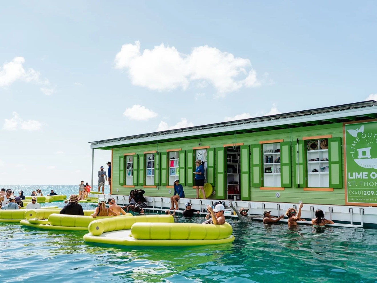Floating bar with people in the ocean, surrounded by inflatable seating.